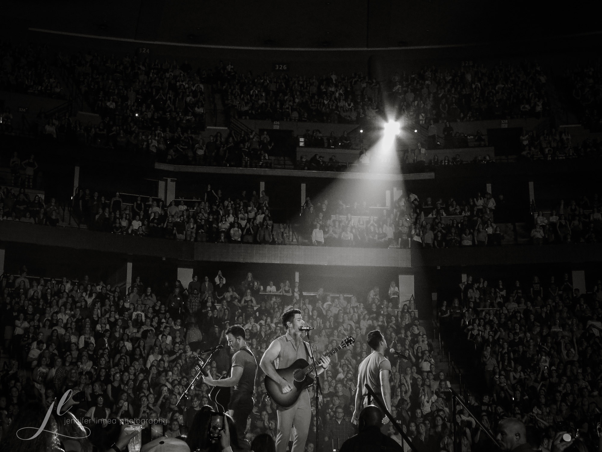 Archival photograph of Jonas Brothers performing in Denver on October 1, 2019; photographer watermark preserved.